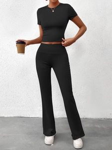 Détail d'un ensemble de yoga noir deux pièces moulant avec crop top et legging évasé