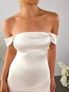 Détail de la robe en satin blanc à épaules dénudées avec plis élégants et texture brillante