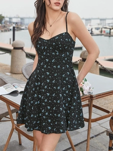 Détail de robe d'été fleurie avec imprimé bleu sur fond noir et fines bretelles