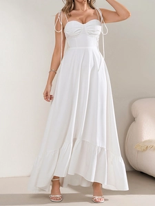Détail de la robe maxi blanche montrant les nœuds d'épaule et l'ourlet à volants