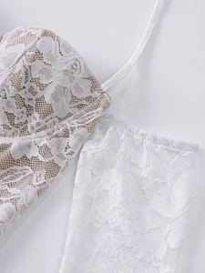 Gros plan sur la dentelle blanche florale avec doublure beige d'une mini robe