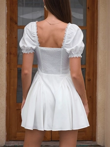 Detail of smocked elastic back and white lace trim on a puff sleeve mini dress