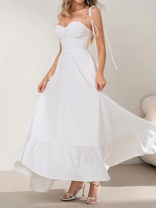 Détail de la robe maxi blanche à bretelles nouées avec bustier plissé et ourlet volanté