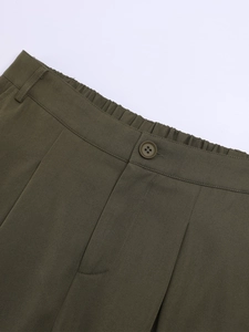 Détail du pantalon cargo à taille haute avec taille élastique et fermeture à bouton en vert olive
