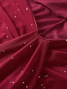 Close-up of wine red mesh fabric with silver square sequins and elegant pleated details