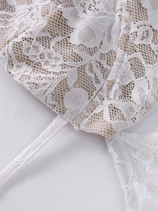 Gros plan sur un tissu en dentelle blanche avec motifs floraux délicats et texture mesh