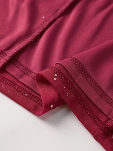 Detailed view of burgundy mesh fabric with silver sequins and double-needle stitching