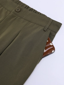Détail du pantalon cargo vert armée montrant la taille élastique, le bouton et la poche latérale