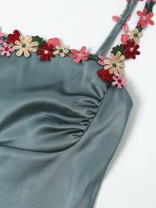 Détail de robe en satin avec broderie florale au décolleté et design de buste froncé