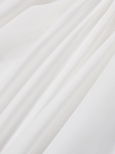 Close-up of premium white textile fabric with fine pleated texture and soft natural light