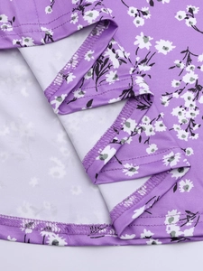 Detail of purple floral dress showing precise hemline stitching and soft knit fabric