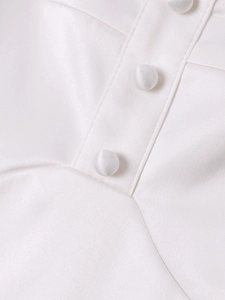 Close-up of white satin summer dress featuring fabric-covered buttons and fine stitching