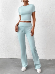 Détail du haut court ajusté vert menthe et du legging évasé montrant la texture du tissu