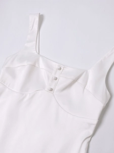Detail of white satin dress featuring square neck, bustier stitching, and three buttons