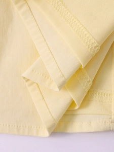 Zoom détaillé sur l'ourlet de robe tencel jaune clair avec coutures fines et texture