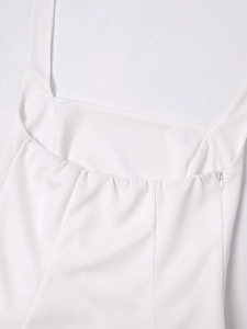 Detailed close-up of white halter dress featuring a square neckline and invisible back zipper