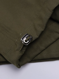 Détail du pantalon vert armée avec cordon de serrage en métal argenté et texture du tissu