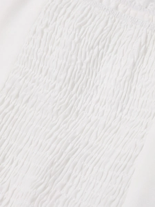 Detail of elegant white smocking fabric and high-quality stitching on a square neck dress