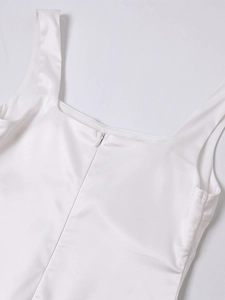 Detail shot of invisible zipper closure and smooth satin texture on white square neck dress