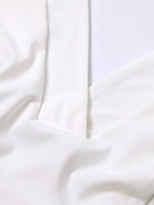 Détail du col en V et de la texture du tissu tissé lisse d'un haut de sport blanc