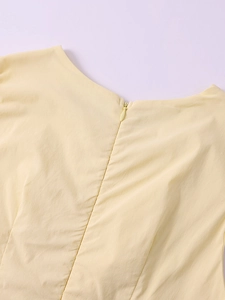 Détail de l'encolure dos et fermeture éclair invisible sur une robe sans manches jaune