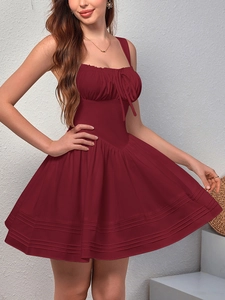 Detail of burgundy backless dress showing shirred chest and ruffled hemline