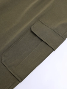 Vue macro d'un pantalon cargo vert armée avec grande poche à rabat et double surpiqûre