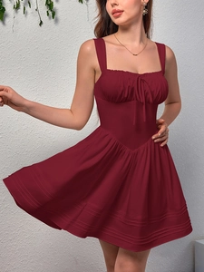 Detail of burgundy backless dress with bow drawstring and ruffled hemline