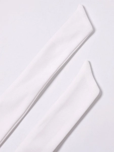 Detail view of the white knitted halter neck ties with fine stitching on the dress