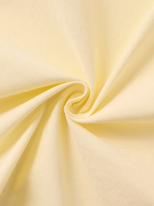 Gros plan sur le tissu tencel jaune pâle révélant une texture côtelée et un drapé doux