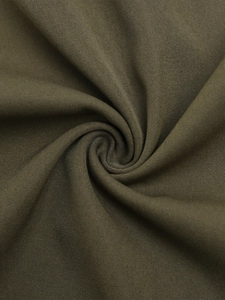 Vue macro de la texture du tissu sergé vert olive foncé pour pantalons cargo taille haute