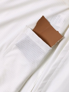 Détail du tissu en maille blanche respirante montrant la texture légère et la poche latérale