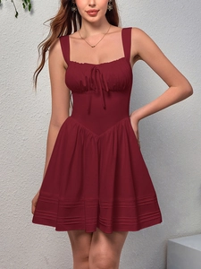 Detail of burgundy mini dress featuring ruffled square neckline and bow drawstring front