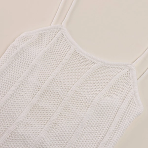 Detailed close-up of white knit camisole texture with hollow crochet pattern work