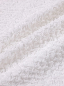 Dettaglio del tessuto popcorn bianco con design a pieghe 3D elastico per abiti da donna