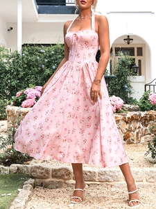 Dettaglio dell'abito floreale con coulisse sul busto e vita aderente su tessuto rosa