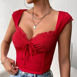 Dettaglio ravvicinato del top a corsetto rosso con pizzo e fiocco decorativo frontale