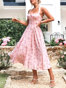 Dettaglio ravvicinato di un abito rosa floreale allacciato al collo con coulisse e pieghe