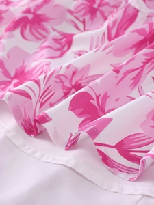 Détail d'imprimé floral rose vif sur tissu blanc avec couture soignée sur une robe d'été