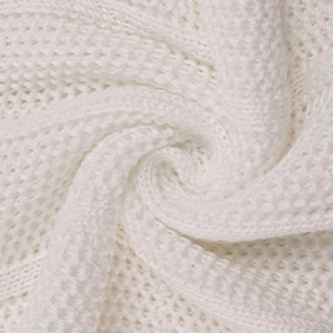 Detailed close-up of white waffle knit texture and crochet pattern on a summer dress