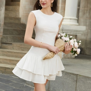 Detail of white sleeveless dress showing tiered ruffle hem and textured Tencel fabric