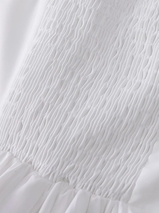 Détail rapproché du tissu smocké blanc d'une robe longue d'été à dos nu sexy