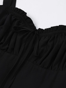 Detail of ruffled neckline and bow tie on a black summer backless A-line dress