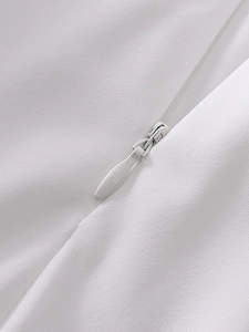 Détail montrant une fermeture éclair invisible sur tissu blanc pour robe élégante