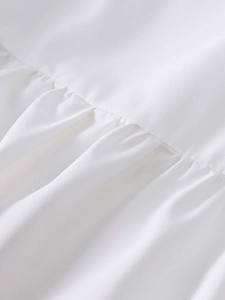 Vue macro détaillée du tissu plissé blanc doux et des coutures fines de la robe longue