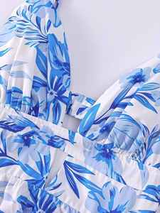 Détail d'une robe d'été fleurie avec décolleté en V, découpe ajourée et tissu plissé