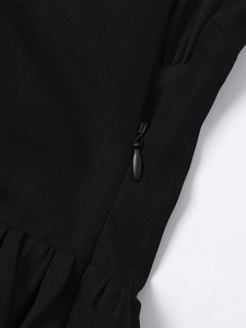 Detailed close-up of invisible side zipper and pleats on black summer mini dress
