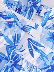 Détail de robe d'été à imprimé floral bleu et blanc avec bretelles plissées et découpe