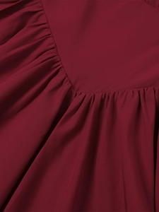 Macro detail of deep red summer dress featuring delicate pleated chiffon and V-seam stitching