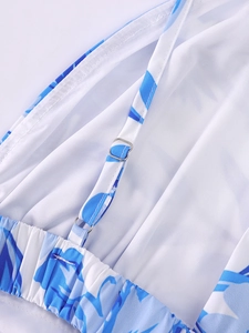 Détail macro des boucles de sangle réglables et de l'imprimé floral bleu sur la robe